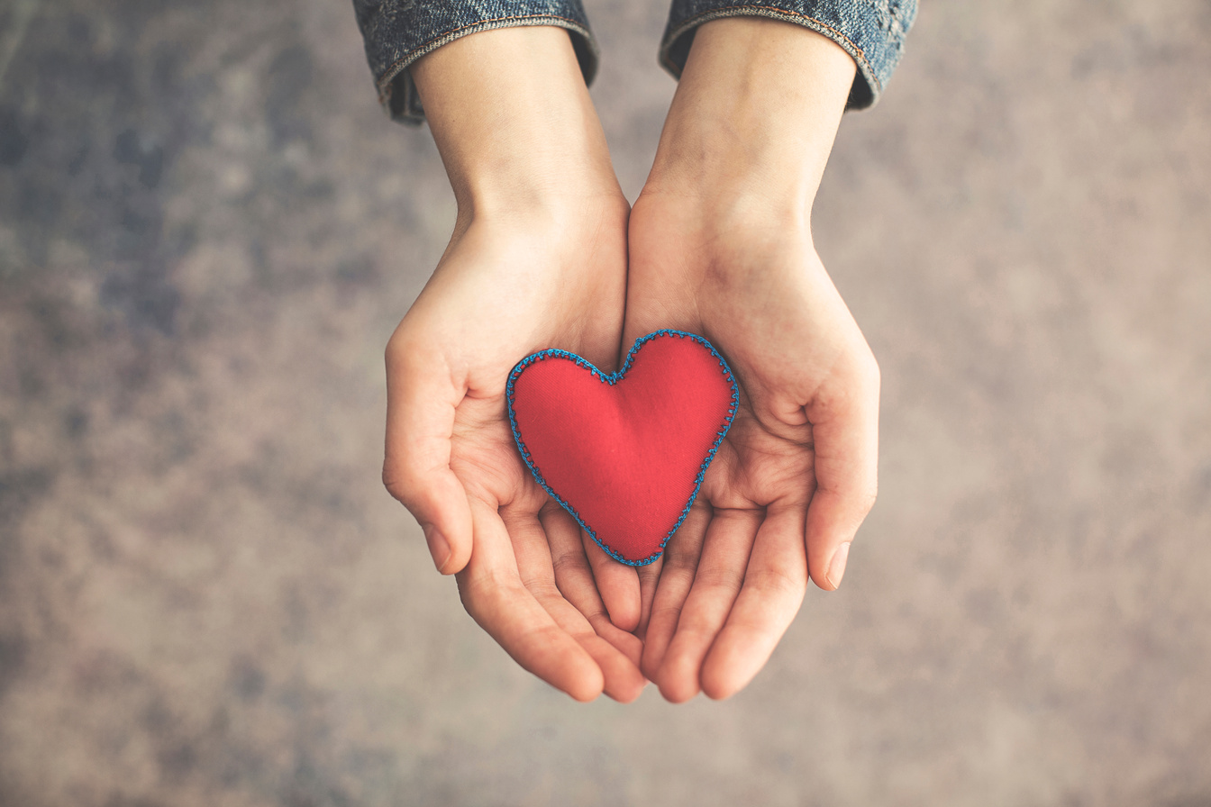 Woman hand holding red heart